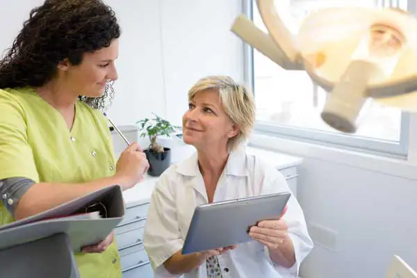 Dental assistant listening to the dentist